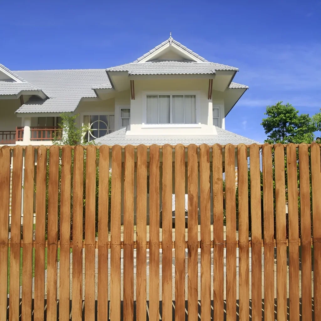 An image showing a classic wood privacy fence in a backyard.