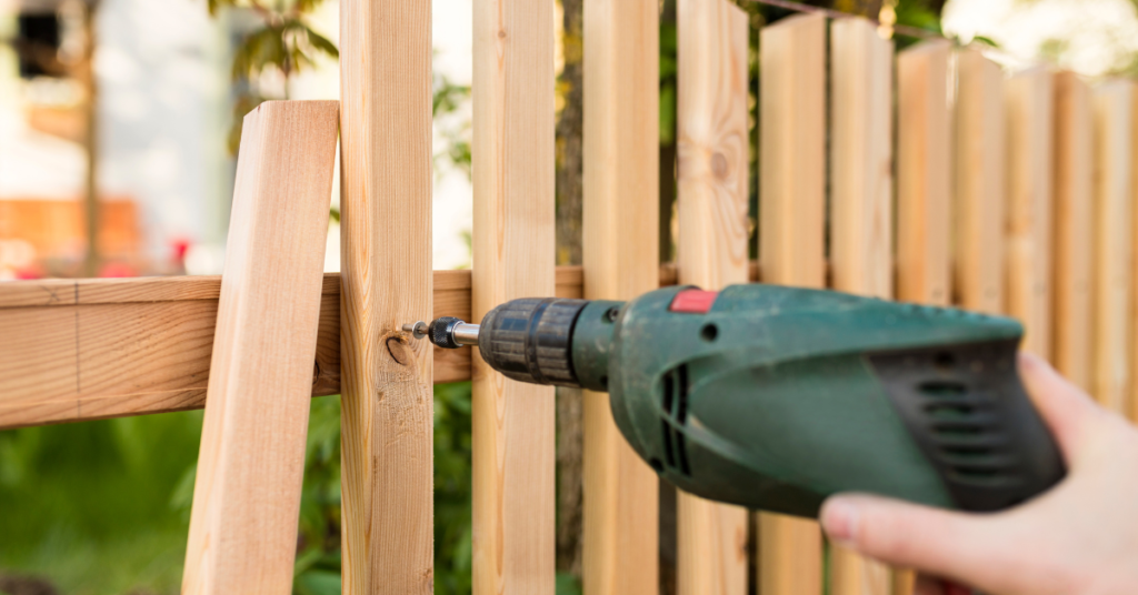 An image showing a professional repairing a wooden fence in a sunny Phoenix, Arizona backyard.