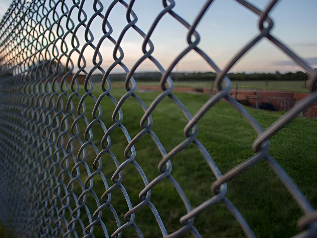 An image showing a chain link fence with vinyl-coated options and privacy slats.