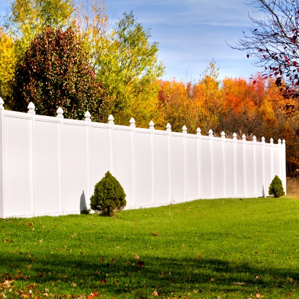 Image of white vinyl fence in sunny backyard.