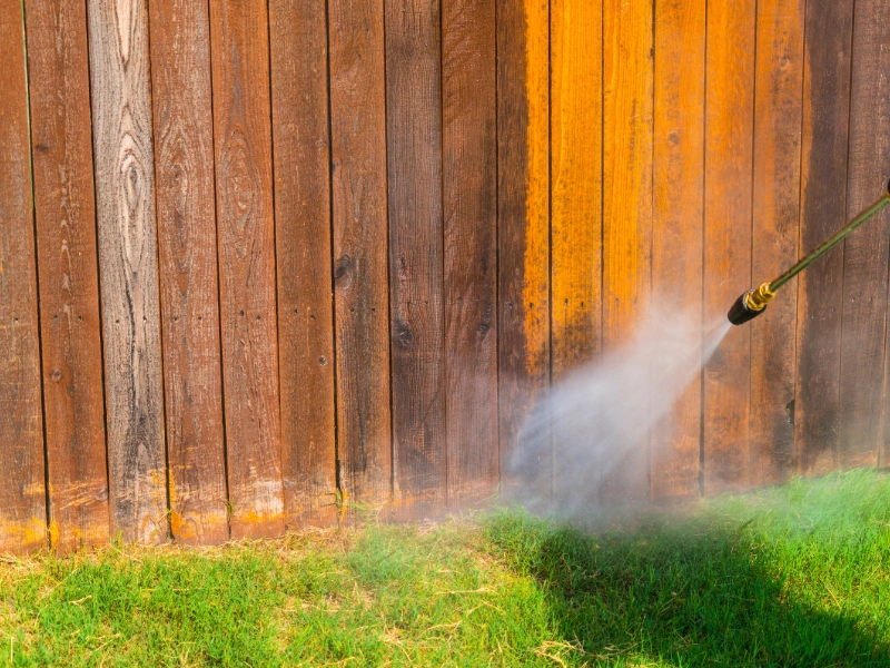 Image showing a vinyl fence being cleaned with a hose.