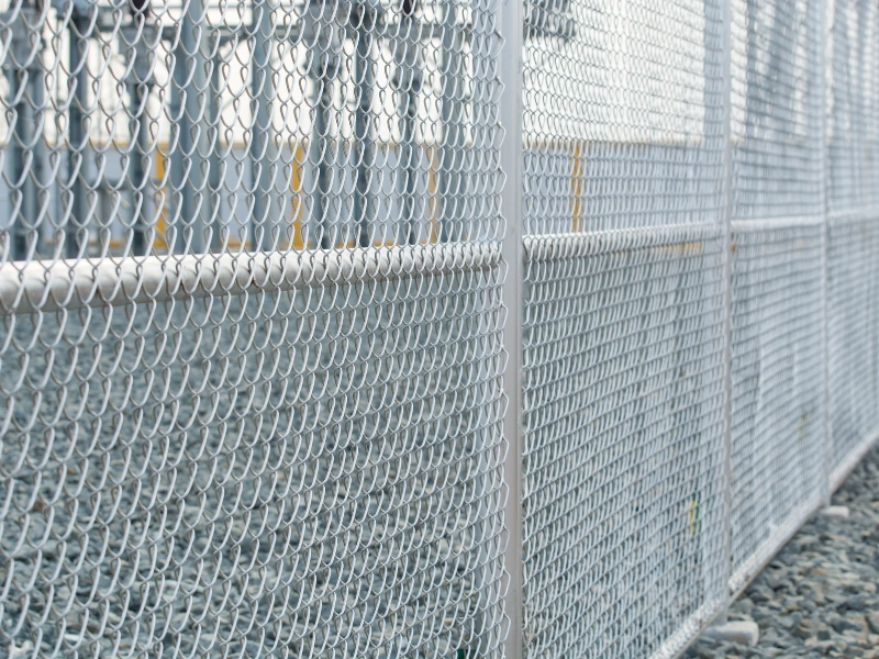 A galvanized chain link commercial security fence.